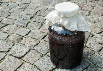 Naklejka premium Large glass jar with sugar soaked sour cherries for alcohol fermentation