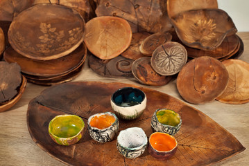 Clay pottery and ceramic products on a wooden table. Home workshop. Handmade with drawings and patterns.