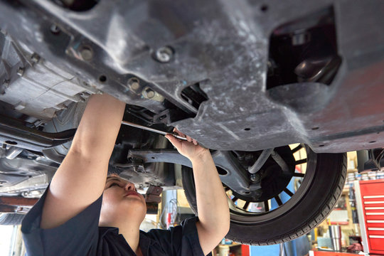 Female Mechanic Working on Cars in Her Shop