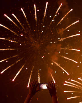 Person taking photos of fireworks using smartphone
