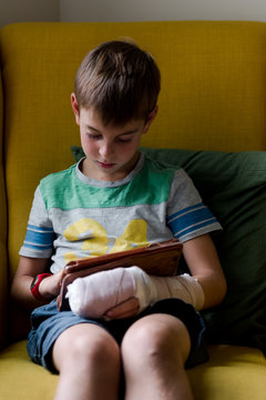 little boy with broken finger on electronic device