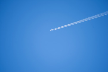 Airplane leaves chemical traces in the blue sky