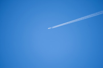 Airplane leaves chemical traces in the blue sky