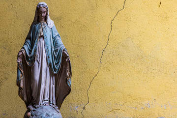 Old Virgin Mary statue, cracked wall background - obrazy, fototapety, plakaty