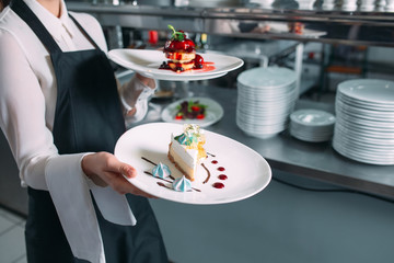 Waiter serving in motion on duty in restaurant. The waiter carries dishes.