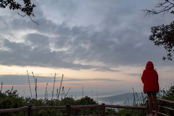 Tourists watching the fog in the mountains and trees.