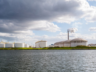 Obraz premium Oil storage tanks and exhaust stack of power station Hemweg in Westpoort, Port of Amsterdam, Netherlands