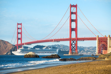 Cruise ship passing Golden Gate Bridge with the skyline of San Francisco in the background,...