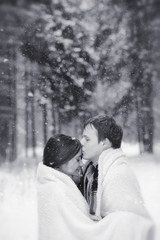 A loving couple on a winter walk. Man and woman on a date in the park in winter. Friends in a winter park