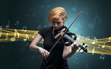 Fototapeta premium Young male musician playing on his violin with musical notes around