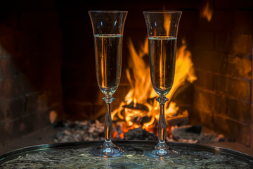 two glasses of  champagne with flame on background