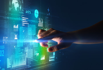 Female finger touching a beam of light surrounded by blue and green data and charts