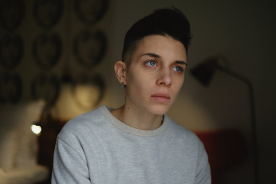 Thoughtful woman with black hair sitting indoors