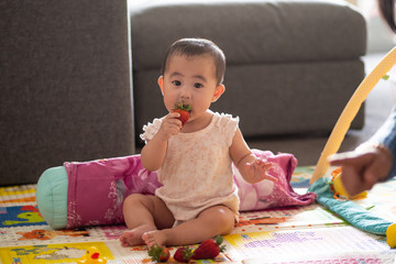 Cute 6 month old baby with strawberries