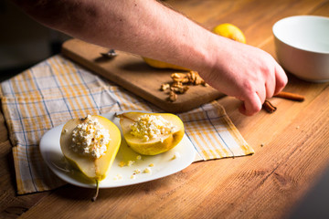 Backstage with a shot of a pear with cottage cheese, nuts, cinnamon and honey on a wooden, subject...