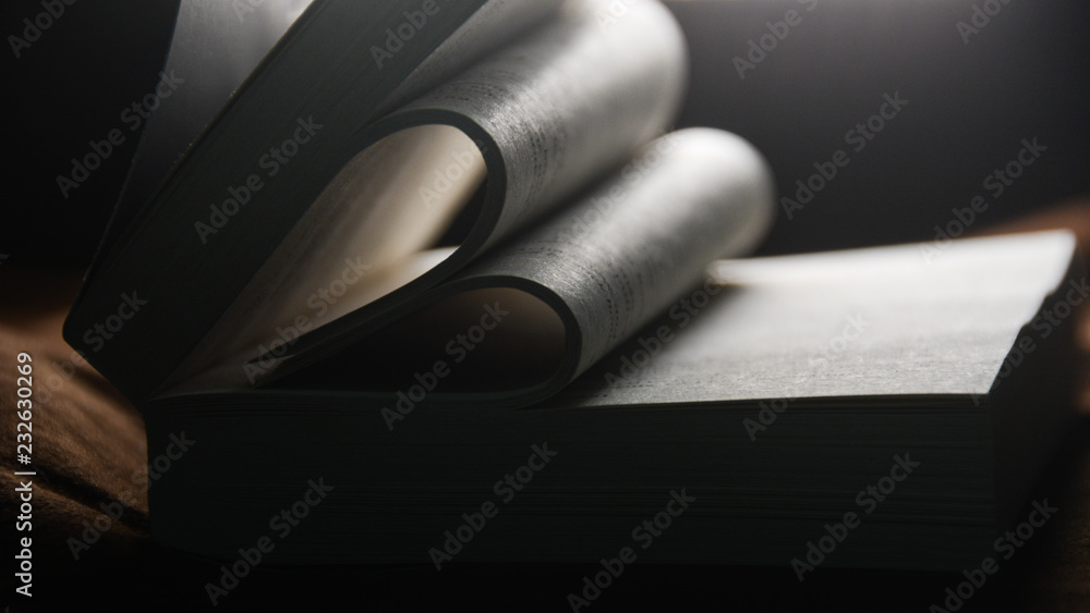 Poster a book with its pages folded into a heart shape. the book is lying on a table.