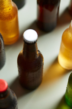 Close-up of wet bottle of beer with cork on table with other bot