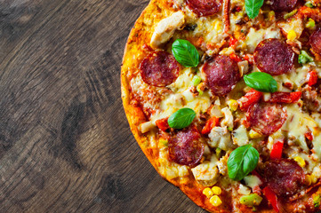 Pizza with Chicken meat, Mozzarella cheese, pepperoni, tomato, vegetables, salami. Italian pizza on wooden background