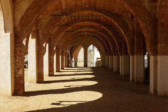 Passage with colonnade on sandy ground