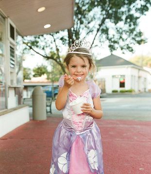 Little Girl Eats Ice Cream In Princess Costume