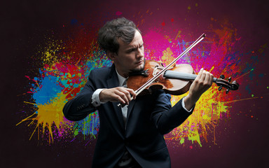 Fototapeta premium Young classical violinist musician with colorful splotch wallpaper 