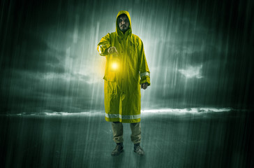 Fototapeta premium Raincoated man walking in storm with glowing lantern in his hand 
