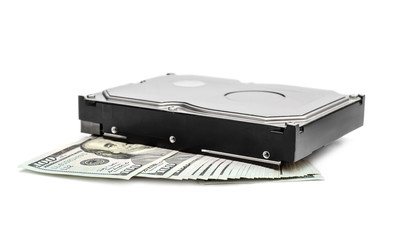 Computer hard disk with dollar bills on white.