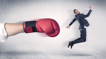 Businessman gets fired from his job by a huge hand in boxing gloves