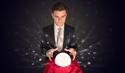 Gorgeous businessman looking to inspiration in a magic ball in his lap and doodle concept
