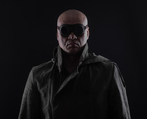 bald man with glasses on a black background