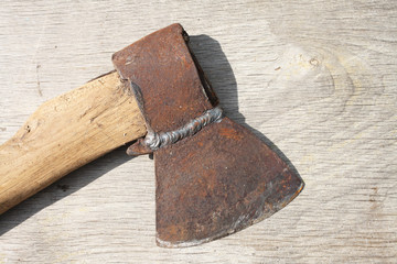 Old rusty axe on wooden background. Toned photo, instagram effect