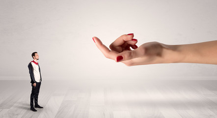 Businessman with kisses on his face in an empty space where a big hand baiting him
