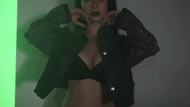 Portrait of woman in lingerie and jacket dancing with projected pattern on her. Music, nightclubs, shows and entertainment concept - video in slow motion