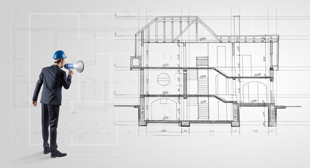 Architect watching a 2 dimension house plan
