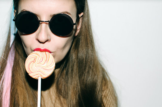 Young woman with lollypop in sunglasses
