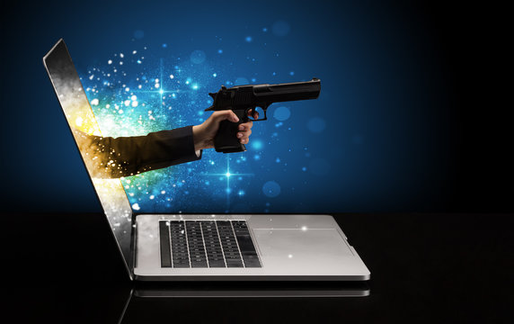 Hand with gun coming out of a laptop with sparkling effects
