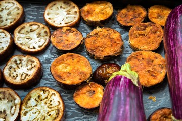 Baked and fried sliced aubergine on baking sheet.