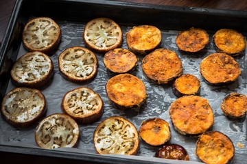 Baked sliced aubergine on pan.