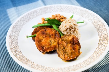 Aubergine, chickpeas, barley pearl and green bean on plate.