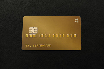 Gold credit card on black leather background