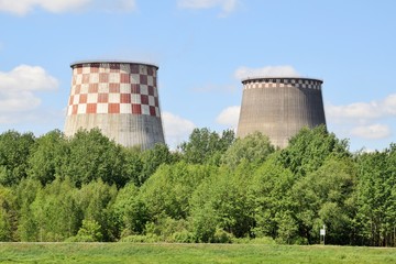 большие трубы теплоэлектростанции на фоне зелёного...