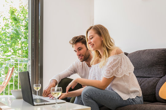 Cheerful Couple Watching Laptop At Home