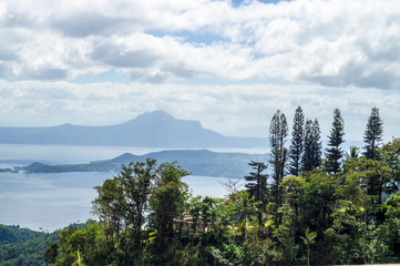 Fototapeta na wymiar Trees on Hilltop Overlooking Lake and Volcano