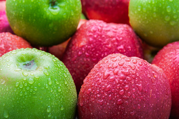 heap of fresh clean green and red apples with drops of water mix on black background, top side view closeup