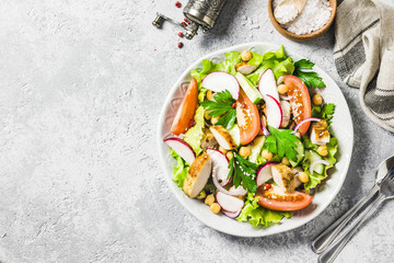 Chicken,garbanzo beans, tomato salad. Top view, space for text.