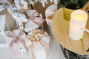 Christmas presents in a different boxes under the Christmas tree in the room or studio