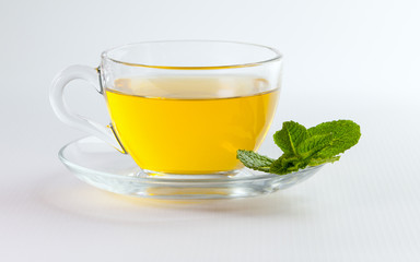 A cup of green tea with mint leaves