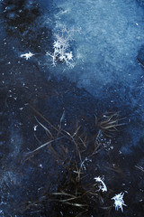 Thin transparent ice on the surface of the reservoir in late autumn