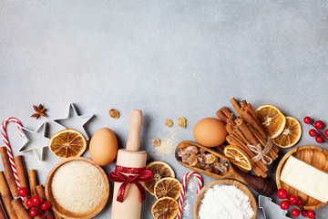 Bakery background with ingredients for cooking christmas baking decorated with fir tree. Flour, brown sugar, eggs and spices top view.