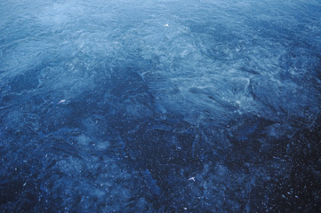Thin transparent ice on the surface of the reservoir in late autumn